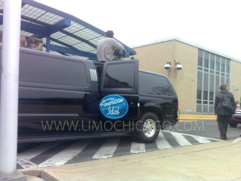 American idol cameraman out of sunroof of black Ford Excursion