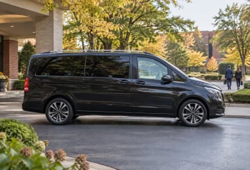 Dark passenger van on a landscaped suburban hotel driveway
